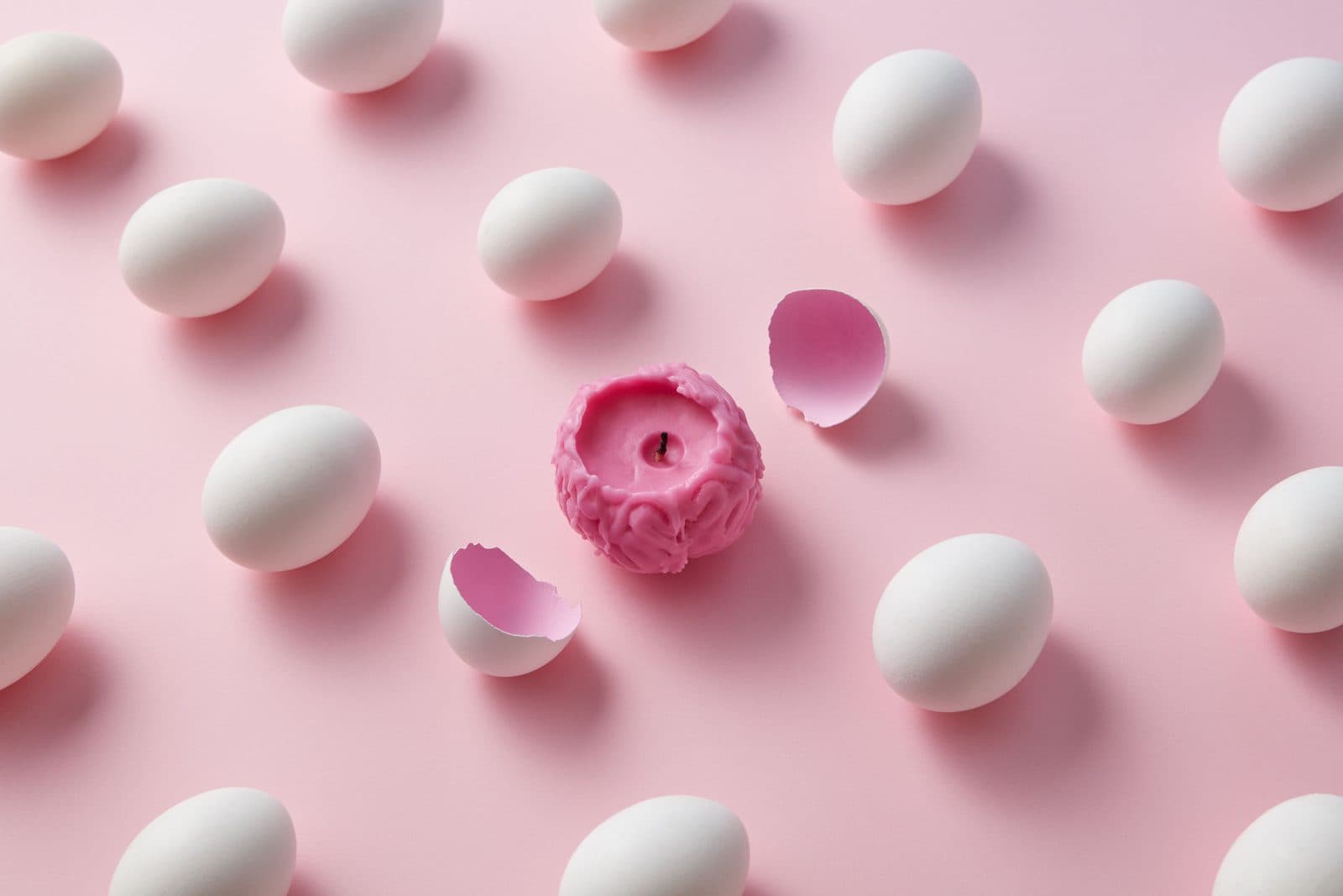 A pink brain candle hatching from an egg